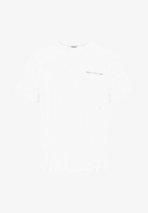 Hvit bomull t-skjorte med rund hals og korte ermer. Har rød tekst som sier "TOKYO" og "JAPAN" øverst til venstre.