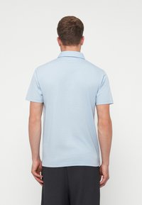 Gaiši zils īsās piedurknes polo krekls ar apkakli. Mīksta auduma, klasiskā piegriezumā un minimālistiskā dizainā bez redzamām rakstām un akcentiem.