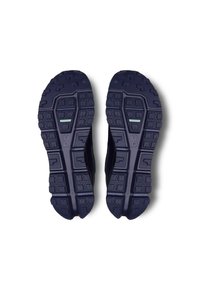 Schwarze und marineblaue Sportschuhsohlen, strukturiertes Gummi mit einem Grip-Muster, ausgestattet mit einem hellblauen Akzentstreifen und Logo.