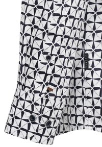 Weißes Hemd mit einem schwarzen geometrischen Muster, das sternartige Formen zeigt. Mit kontrastierenden Knöpfen und einem Markenlabel an der Seite.