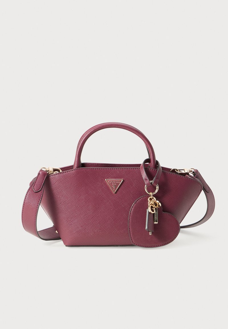 Borsa a tracolla viola con manici superiori, tracolla e ciondolo a forma di cuore con accenti dorati e logo del brand.