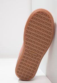 Semelle de chaussure Puma, en caoutchouc texturé beige avec un motif géométrique et un logo bien visible au centre.