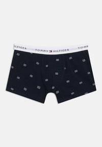 Μπλε ναυτικό boxer briefs Tommy Hilfiger με λευκή ζώνη μέσης με λογότυπο και μικρά λευκά σχέδια σημαίας διασκορπισμένα στο ύφασμα.