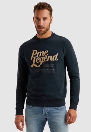 Navy cotton sweatshirt with gold printed text "Pme Legend" and smaller text below. Features ribbed cuffs and hem; crew neckline.