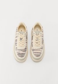 Sneakers met een bovenstuk van gestructureerde stof in crème, voorzien van geweven multicolore strepen, ronde neus, vetersluiting en een rubberen zool.