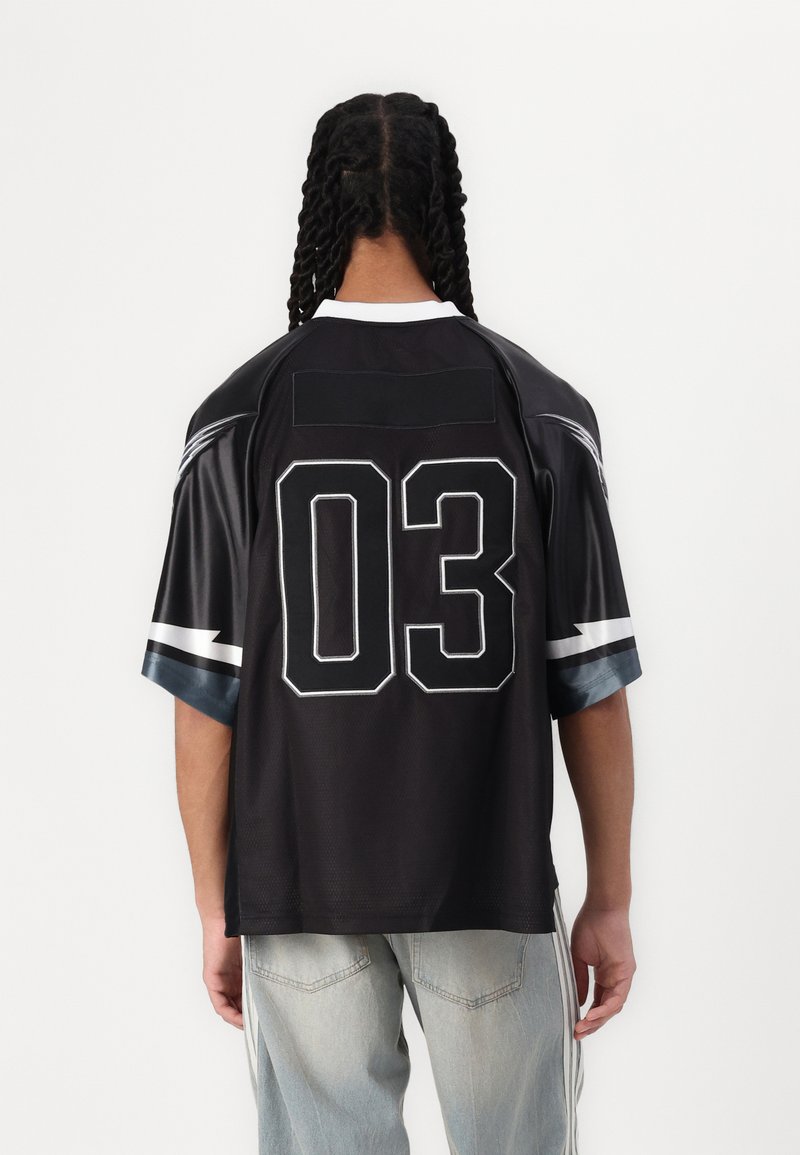 Un maillot de sport noir avec des manches courtes, un col ras du cou et un grand numéro blanc "03" imprimé au dos. Accentué de rayures grises.