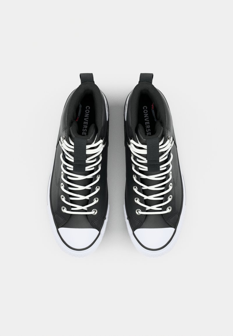 Baskets montantes en matériau synthétique noir avec bouts et lacets en caoutchouc blanc. Remarquables par leurs tirants et le logo de la marque à l'intérieur.