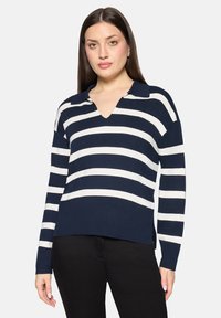 Pull rayé bleu marine et blanc avec un col en V et un design col. Confectionné en matière douce, avec des manches longues et une coupe décontractée.