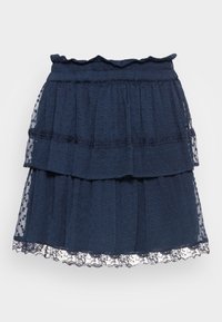 Jupe bleu marine à volants, en tissu texturé, avec une taille froncée et une bordure en dentelle à l'ourlet. Design en couches avec des pois.