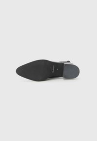 Suola di scarpa in pelle nera a forma appuntita. Grip in gomma testurizzata con il marchio "GANT" e la taglia "37" stampata sul lato.