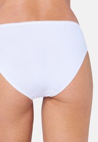Weiße Baumwollunterhose mit glatter Textur, vollständiger Abdeckung und kontrastierenden Nähten entlang des Taillenbunds und der Beinöffnungen.