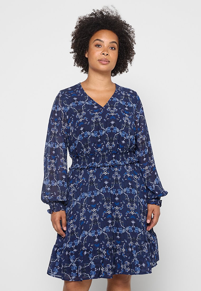 Blauwe bloemenjurk met lange pofmouwen, V-hals, elastische taille en gerimpelde zoom. Gemaakt van doorzichtige, lichte stof met ingewikkelde patronen.