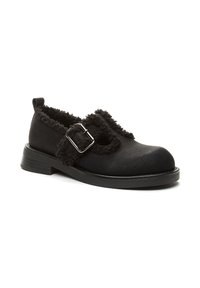 Czarne buty Mary Jane wykonane z teksturowanej skóry, z obszyciem z owczej wełny, srebrną klamrą i płaską podeszwą, ustawione pod kątem, aby pokazać zewnętrzną stronę i obcas.