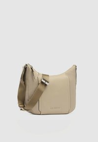 Borsa a tracolla in pelle beige con una texture liscia, chiusure a zip e una larga tracolla in tessuto con dettagli metallici. Presenta il logo del marchio.