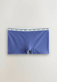 Boxers pour homme bleus avec ceinture élastique blanche ornée du texte répété "NEXT" en noir, posés à plat sur un fond clair.