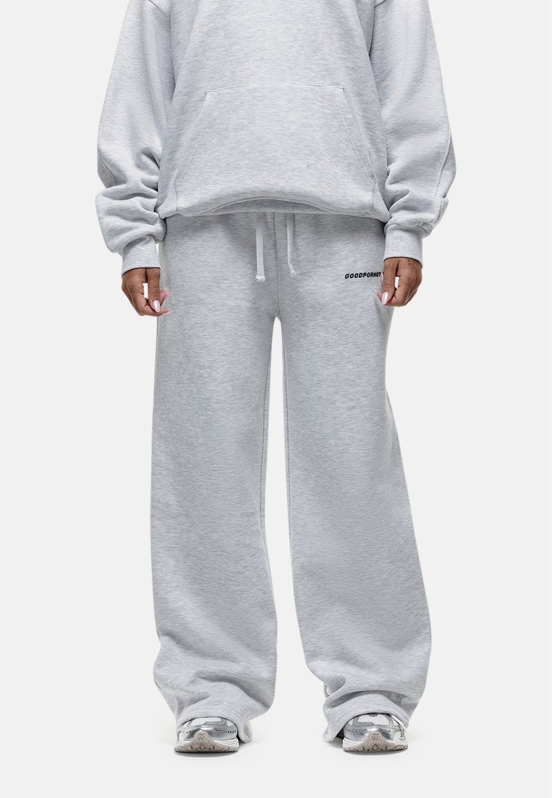 Grijze sweatshirt met een losse pasvorm en oversized mouwen, gecombineerd met bijpassende wijde sweatpants. Beide hebben een zachte textuur en minimale logo-details.