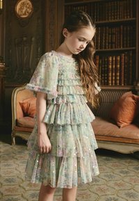 Rétegezett világoszöld ruha virágmintákkal, fodros ujjakkal és flitterekkel. Részletes textúra, puha anyagból, térdig érő szegéllyel.