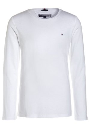 Weißes langärmeliges Baumwollhemd mit Rundhalsausschnitt, kleinem Tommy Hilfiger-Logo auf der Brust und Markenetiketten im Kragen.