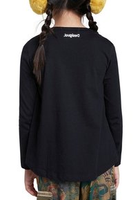 Svart långärmad skjorta med en lätt rundad nederkant och en vit logotyp på baksidan. Mjuk, slät tyg med en avslappnad passform.