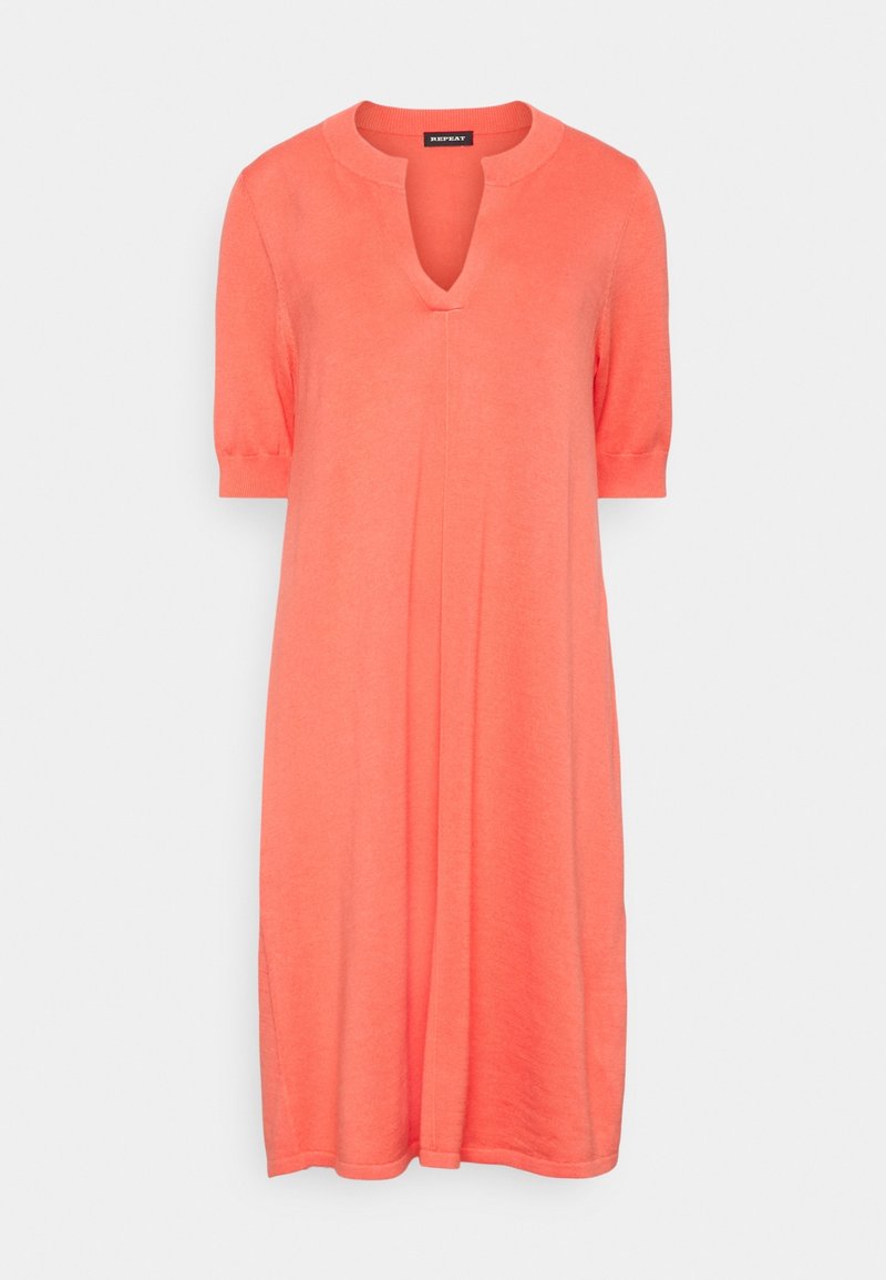 Korallenfarbenes Strickkleid mit V-Ausschnitt und kurzen Ärmeln, das eine lässige A-Linien-Silhouette und Seitenschlitze für mehr Bewegungsfreiheit bietet.