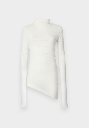 Hvit langermet topp med høy hals, med en asymmetrisk hemline og teksturert stoff som faller mykt. Glatt, tettsittende design.