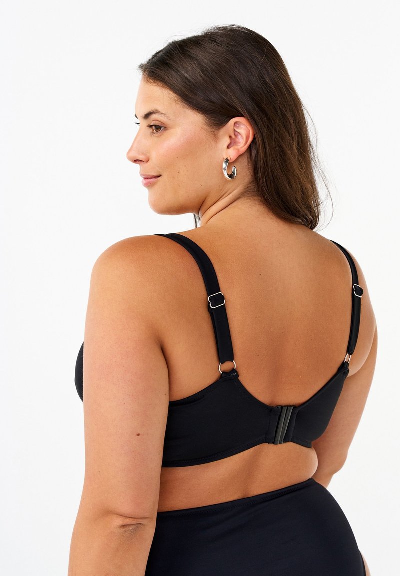 Reggiseno nero con spalline regolabili, texture liscia e chiusura con gancetto sul retro, progettato per comfort e supporto.