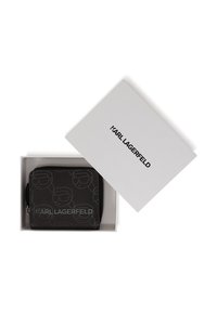 Portefeuille en cuir noir texturé à motif gaufré répété. Emballé dans une boîte blanche avec le logo "KARL LAGERFELD" sur le dessus.