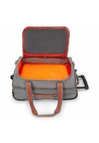 Bolsa de viaje enrollable gris con un interior naranja; cuenta con dos asas, un asa retráctil y un bolsillo de malla con cremallera en la tapa.