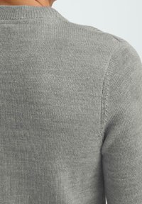 Gray knitted sweater, featuring a fine texture and rounded neckline. The back shows seamless stitching at the shoulder and spine areas.