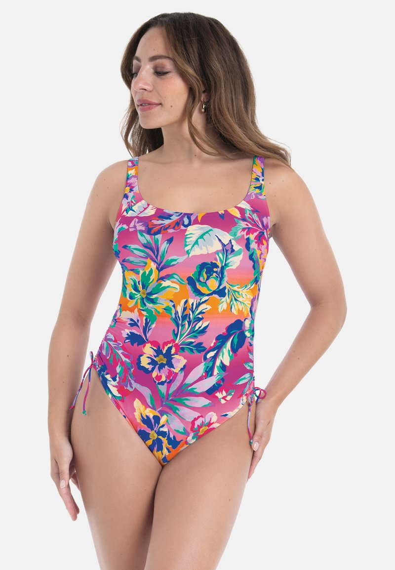 Värikäs yksiosainen kukkakuvioinen uimapuku, jossa on vihreitä ja keltaisia korostuksia, neliömäinen pääntie, paksut olkaimet ja sivusolmimisdetaljit.