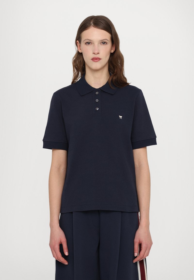 Marineblå polo t-skjorte i bomull, med klassisk krage, korte ermer, tre-knappers stolpe og en liten brodert logo på brystet.