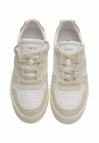 Sneakers bianchi e beige con tomaia in tessuto testurizzato, punta perforata e dettagli cuciti. Presentano lacci beige e un marchio sulla linguetta.