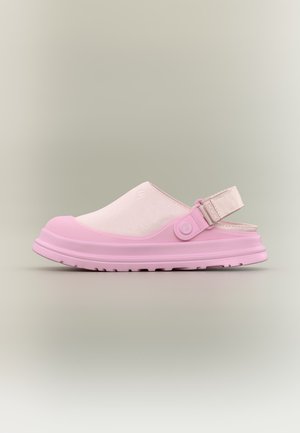 Rózsaszín klumpa, sima orr résszel, puha szövet felsőrésszel, állítható hátsó pánttal és texturált talppal, semleges háttéren.