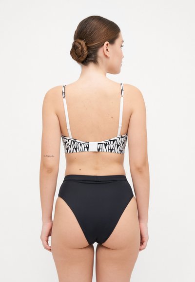 High-waisted black bikini bottom paired with a patterned black-and-white bralette. Adjustable straps and a clasp closure are visible.