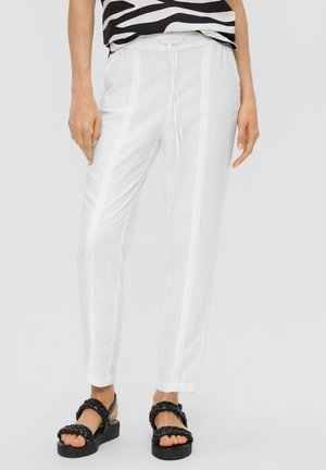 White linen trousers with a drawstring waist, featuring vertical stripes and a tapered fit. Paired with black braided sandals.