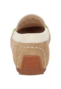 Beige Wildlederschuh zum Hineinschlüpfen mit cremefarbenen Akzenten, grünen Details und einem braunen Lederetikett an der Ferse, das mit "Sioux Since 1954" geprägt ist.