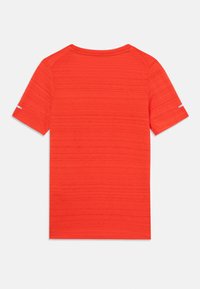 Camiseta roja de manga corta con un tejido texturizado, cuello redondo y un detalle reflectante en la manga. Acabado suave, diseño ligero.
