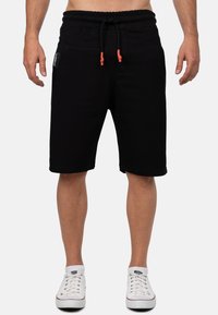 Zwarte katoenen sportshorts met een elastische tailleband en trekkoord, met zijzakken en een knielengte.