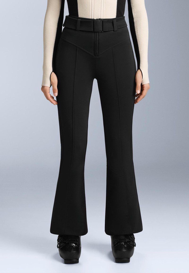 Fekete harangszárú nadrág rugalmas anyagból, elülső varratokkal, magas derékkal és övhurkokkal. Fekete platform cipővel párosítva.