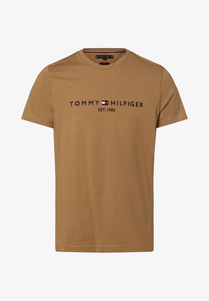 Ruskea puuvillapaita, jossa on pyöreä kaula-aukko, lyhyet hihat ja logo, jossa lukee "TOMMY HILFIGER EST. 1985" tummansinisellä ja punaisella. Liukas rakenne, rento muotoilu.