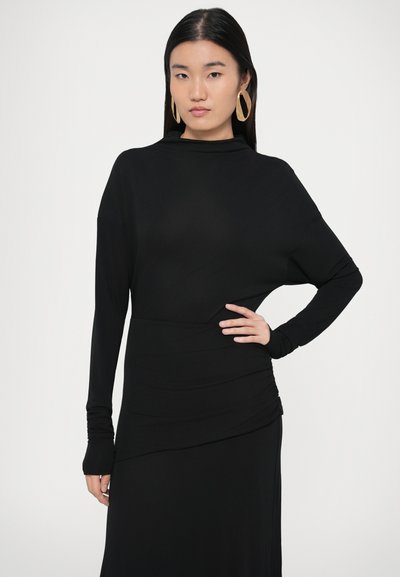 Fekete hosszú ujjú ruha sima anyagból, magas nyakkal és deréknál összehúzott részlettel a testhezálló sziluett érdekében.