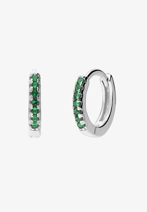 Boucles d'oreilles créoles en argent ornées d'une rangée de pierres précieuses vertes rondes sur la surface avant, sur fond blanc.