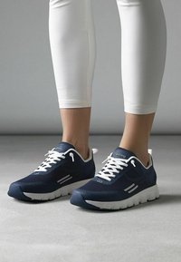 Námořnické sportovní boty s texturovaným svrškem, bílými tkaničkami a kontrastní podrážkou. Mají minimální bílé detaily a pohodlný design.