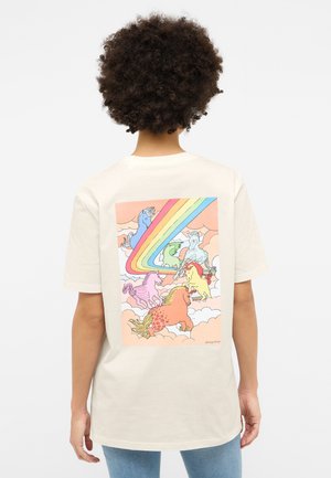 Cream-colored t-shirt featuring a colorful graphic of unicorns and a rainbow against a pastel background. Short sleeves, relaxed fit.