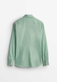 Jasnozielona koszula z długim rękawem, kołnierzykiem, mankietami na guziki i gładką fakturą. Z tyłu jednolita, bez widocznych wzorów i logo.