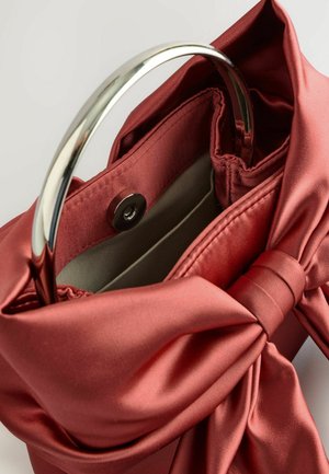 Borsa in raso rosso con manico circolare in argento, caratterizzata da un dettaglio a fiocco e una chiusura a scatto. All'interno ha una morbida fodera in tessuto.