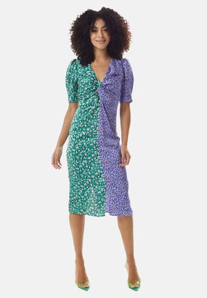 Colorful knee-length dress featuring a twist front design. One side is green with a pattern, while the other is blue with abstract accents.