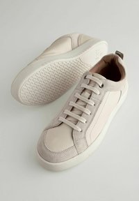 Helle Sneakers mit einer Mischung aus glatten und strukturierten Materialien, auffälligen Schnürsenkeln, runder Zehenpartie und einer gemusterten Gummisohle.