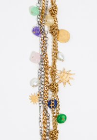 Collana in metallo misto con catene d'oro e argento, gemme colorate, dischi rotondi d'oro e accenti a forma di stella.