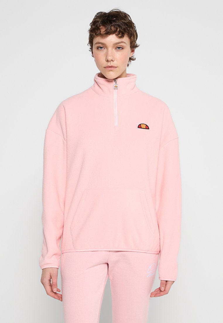 Pull-over en polaire rose clair avec une demi-fermeture éclair, poche kangourou et logo brodé sur la poitrine. Texture douce et coupe décontractée.